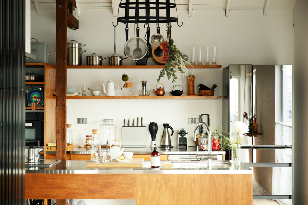 Bild på ett mellanstort nordiskt kök, med en integrerad diskho, öppna hyllor, bruna skåp, bänkskiva i rostfritt stål, vitt stänkskydd, glaspanel som stänkskydd, rostfria vitvaror, ljust trägolv, en halv köksö och beiget golv