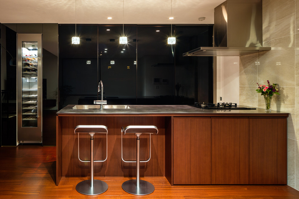 東京23区にあるコンテンポラリースタイルのおしゃれなキッチン (シングルシンク、フラットパネル扉のキャビネット、中間色木目調キャビネット、ステンレスカウンター、無垢フローリング、茶色い床) の写真