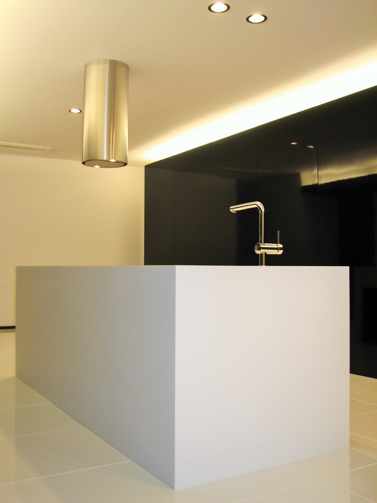 Idee per una cucina moderna di medie dimensioni con lavello integrato, ante lisce, ante bianche, top in superficie solida, elettrodomestici neri e pavimento con piastrelle in ceramica