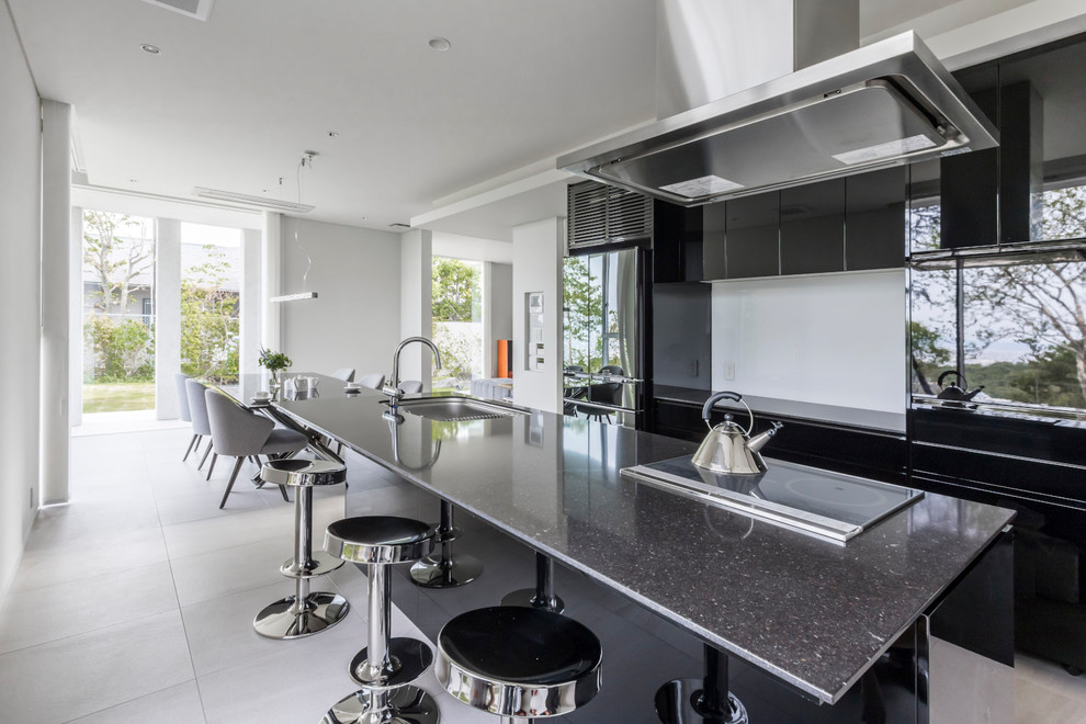 Foto di una cucina contemporanea con ante nere, paraspruzzi nero, elettrodomestici neri, pavimento beige, lavello a vasca singola e ante lisce