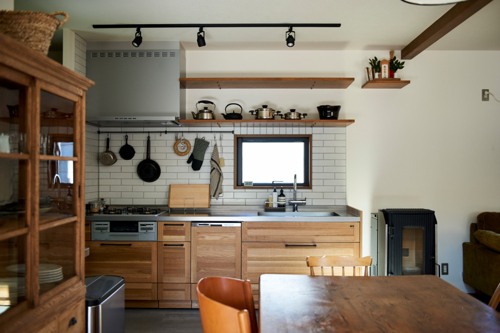 Idee per una cucina etnica con ante in stile shaker, ante in legno scuro, paraspruzzi bianco, pavimento in cemento, pavimento grigio e top grigio