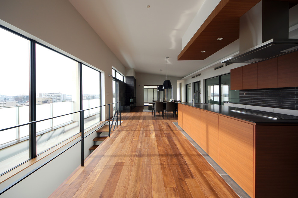 Foto de cocina lineal minimalista abierta con fregadero de un seno, armarios con paneles lisos, una isla, suelo gris y puertas de armario de madera oscura