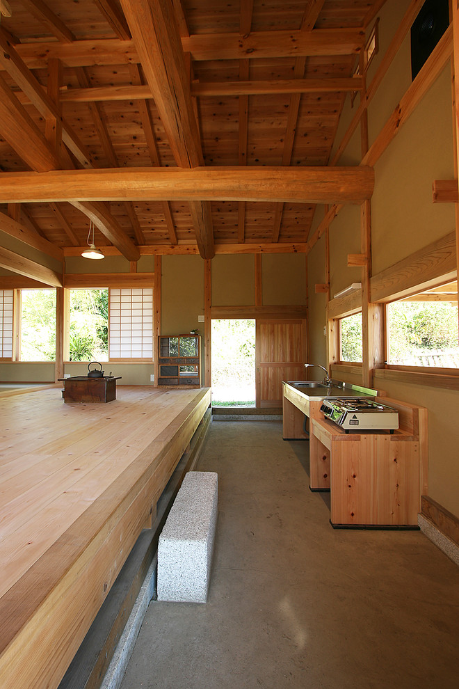 Imagen de cocina de estilo zen con fregadero de un seno, armarios abiertos, encimera de acero inoxidable, suelo de cemento y suelo gris
