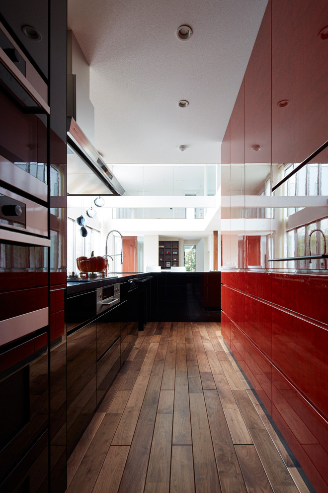 Foto di una cucina contemporanea di medie dimensioni con ante lisce, elettrodomestici in acciaio inossidabile e penisola