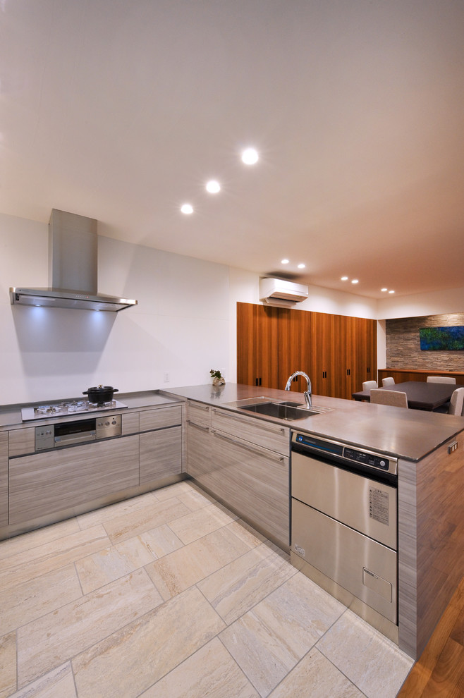 Источник вдохновения для домашнего уюта: п-образная кухня-гостиная в стиле модернизм с одинарной мойкой, плоскими фасадами, серыми фасадами и бежевым полом