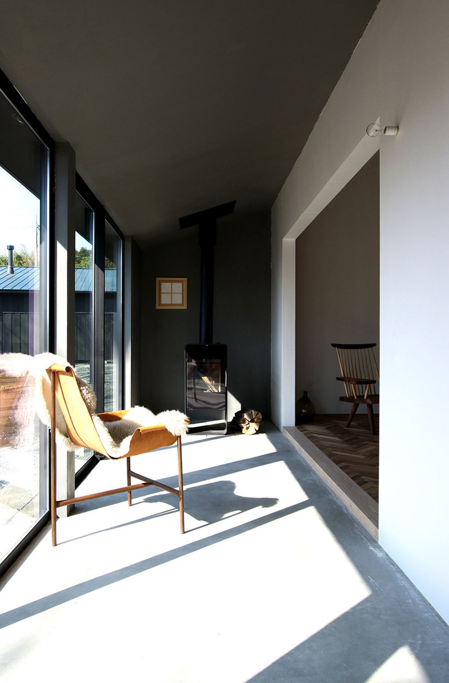 Источник вдохновения для домашнего уюта: терраса в стиле рустика с бетонным полом, печью-буржуйкой, стандартным потолком и серым полом