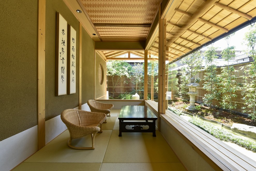 Cette image montre une véranda asiatique avec un plafond standard et un sol vert.