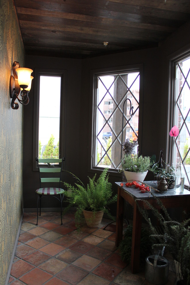 Foto på ett uterum, med klinkergolv i terrakotta och flerfärgat golv