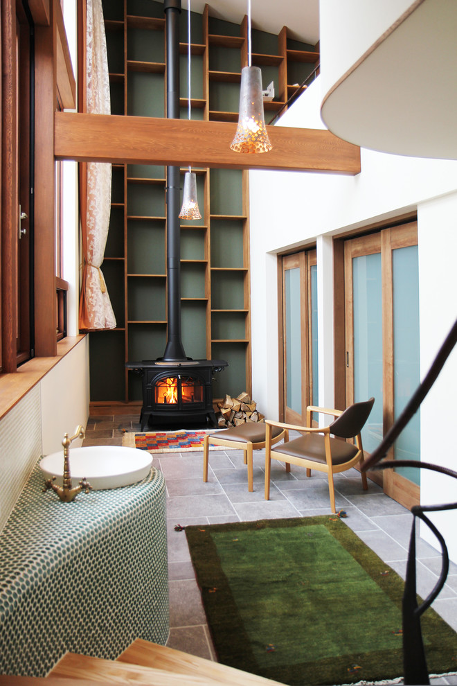 Aménagement d'une véranda moderne avec un plafond standard, un sol gris, un poêle à bois et un manteau de cheminée en carrelage.