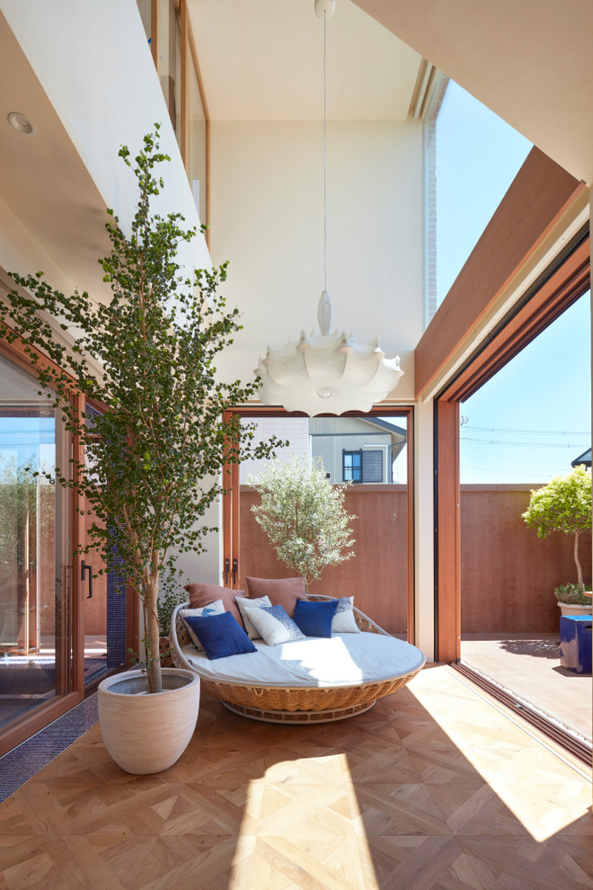 Esempio di una veranda mediterranea con pavimento in legno massello medio, soffitto classico e pavimento marrone