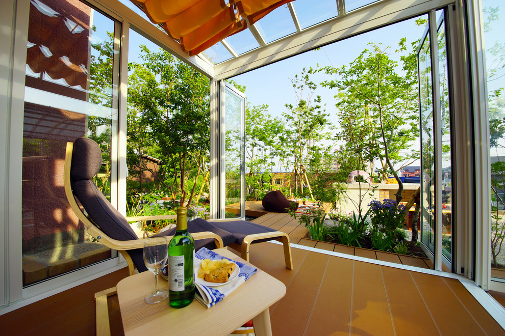 Immagine di una veranda moderna con pavimento in terracotta, soffitto in vetro e pavimento marrone