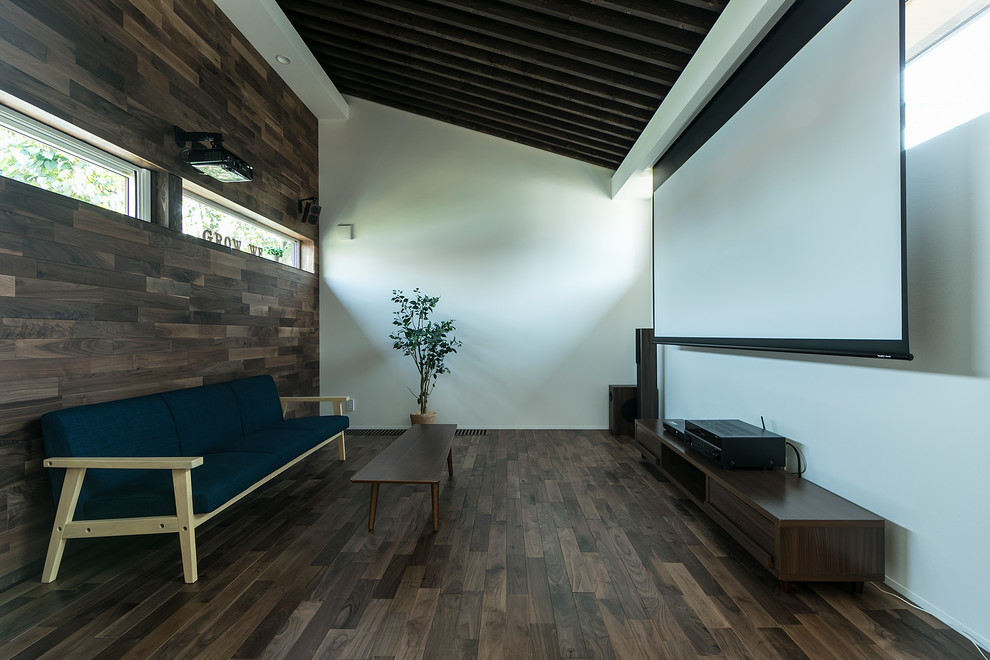 This is an example of a world-inspired home cinema in Sapporo with white walls, dark hardwood flooring, a projector screen and brown floors.