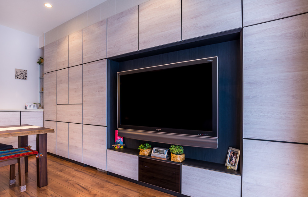 Asiatisk inredning av ett stort öppen hemmabio, med vita väggar, plywoodgolv, en väggmonterad TV och brunt golv