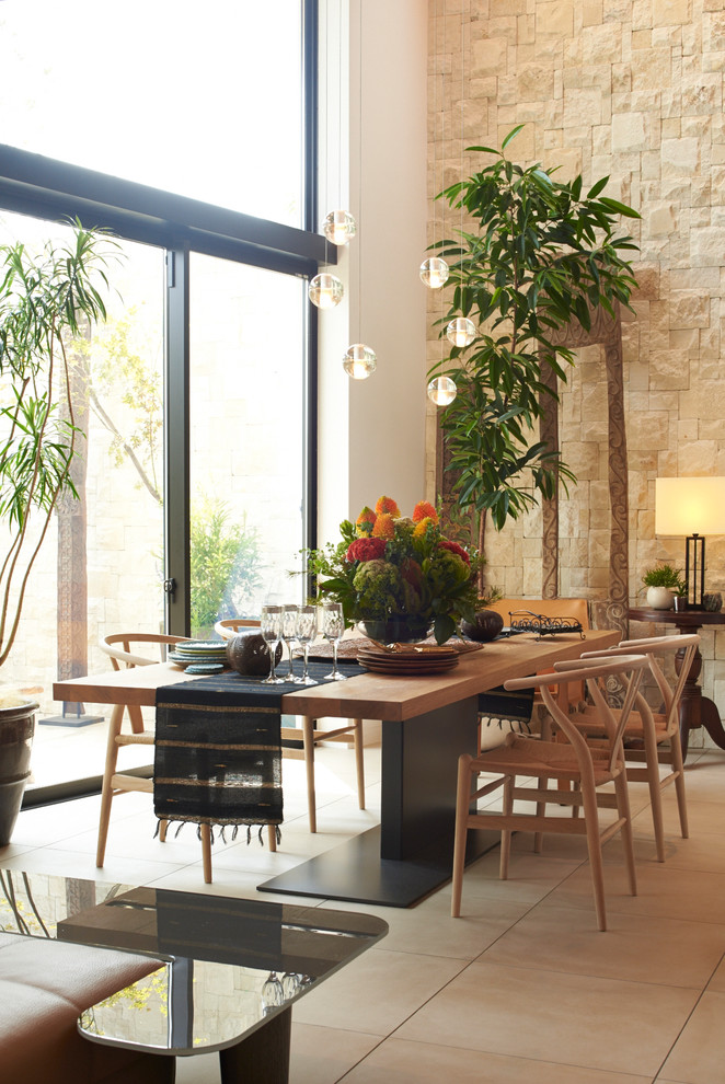 Foto di una sala da pranzo aperta verso il soggiorno etnica con pareti beige e pavimento beige