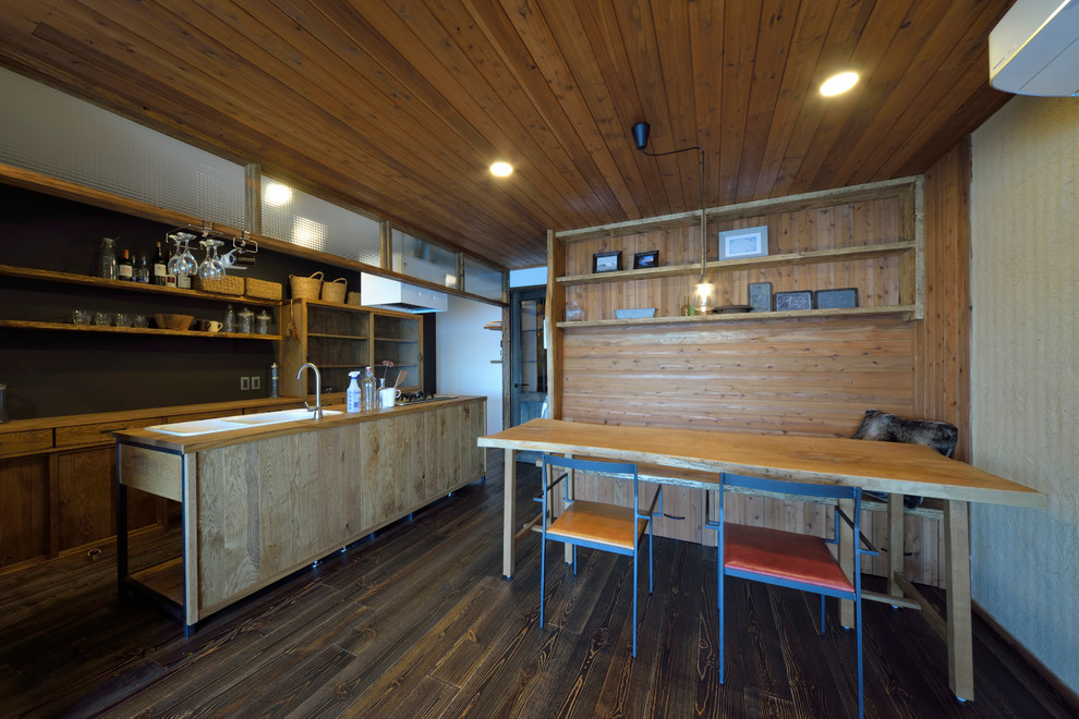 Cette photo montre une salle à manger ouverte sur le salon asiatique avec un mur blanc, parquet foncé et un sol marron.