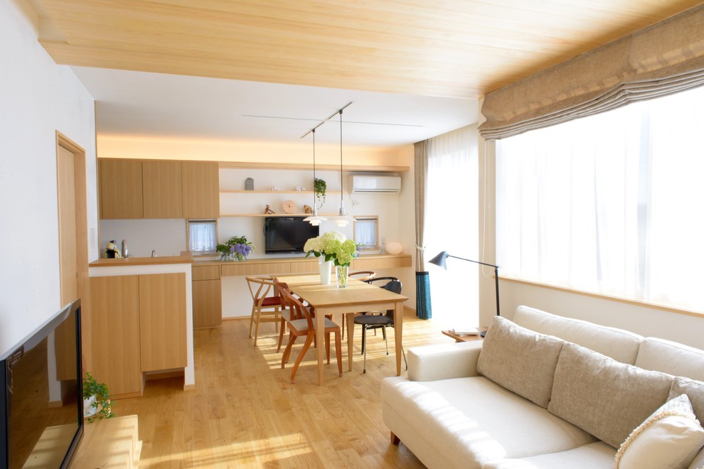 Diseño de comedor escandinavo de tamaño medio abierto sin chimenea con paredes blancas, suelo de madera en tonos medios y suelo marrón