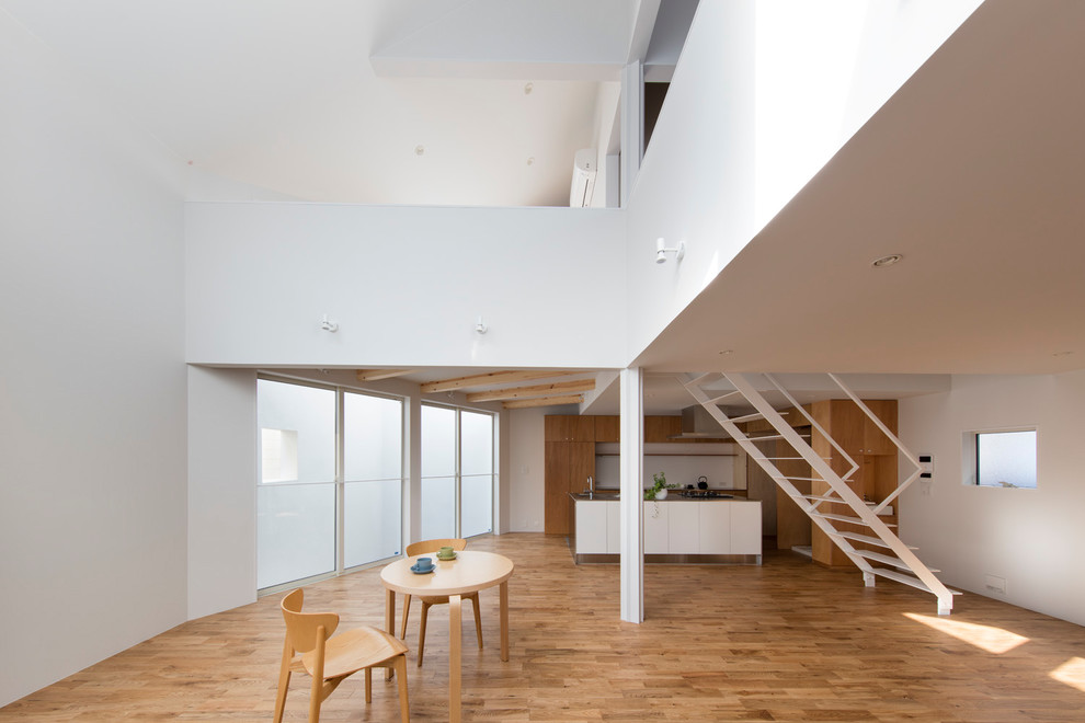 Photo of a contemporary open plan dining room in Tokyo with white walls, medium hardwood flooring and brown floors.