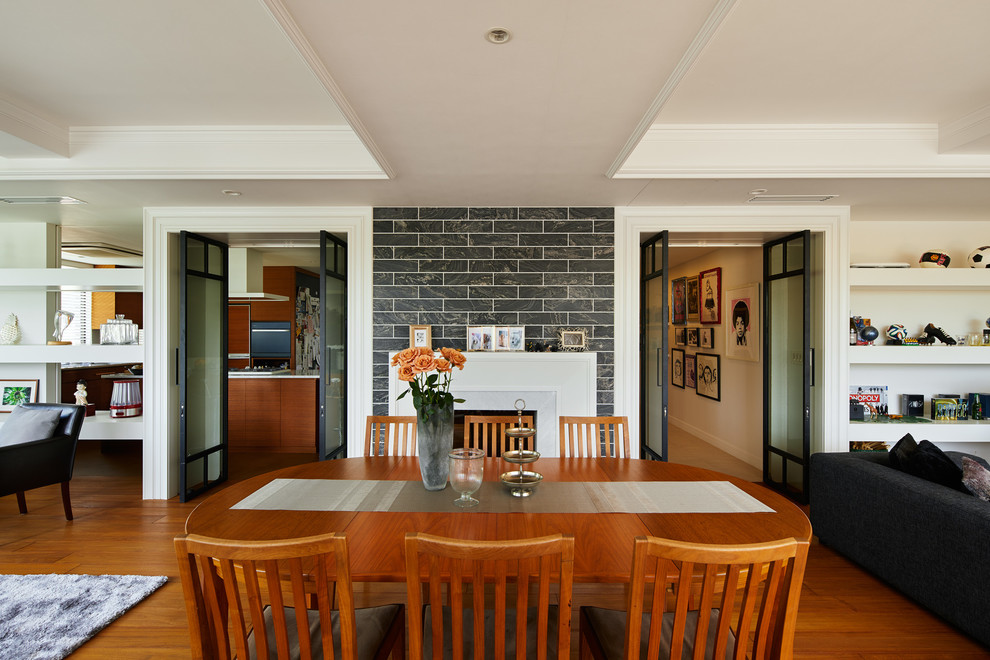 Réalisation d'une salle à manger vintage avec un mur blanc, un sol en bois brun et un sol marron.