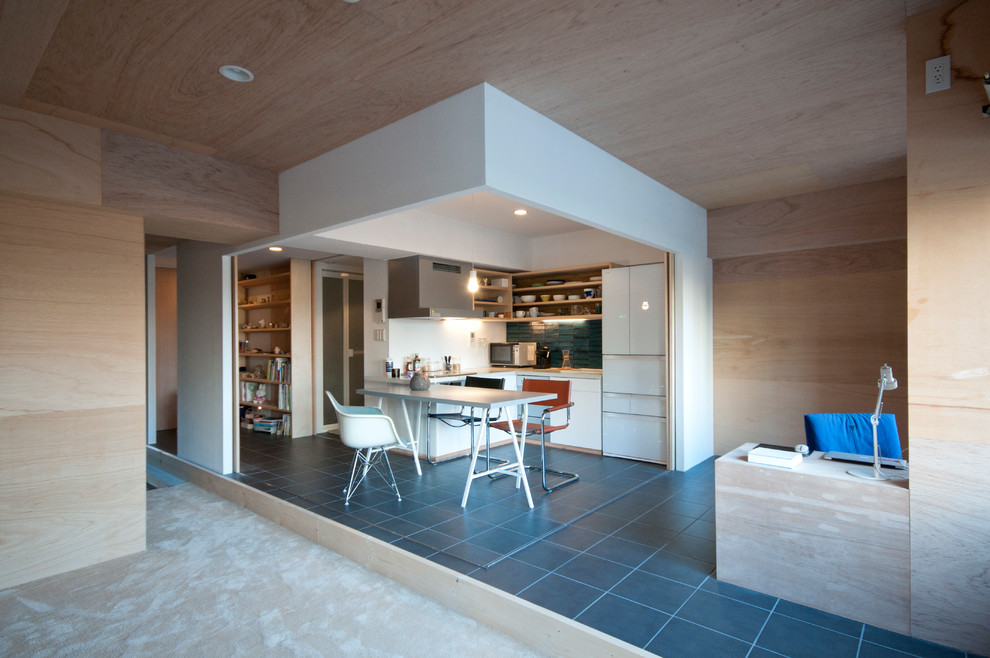 Immagine di una piccola sala da pranzo aperta verso il soggiorno design con pareti beige, pavimento con piastrelle in ceramica, nessun camino e pavimento nero