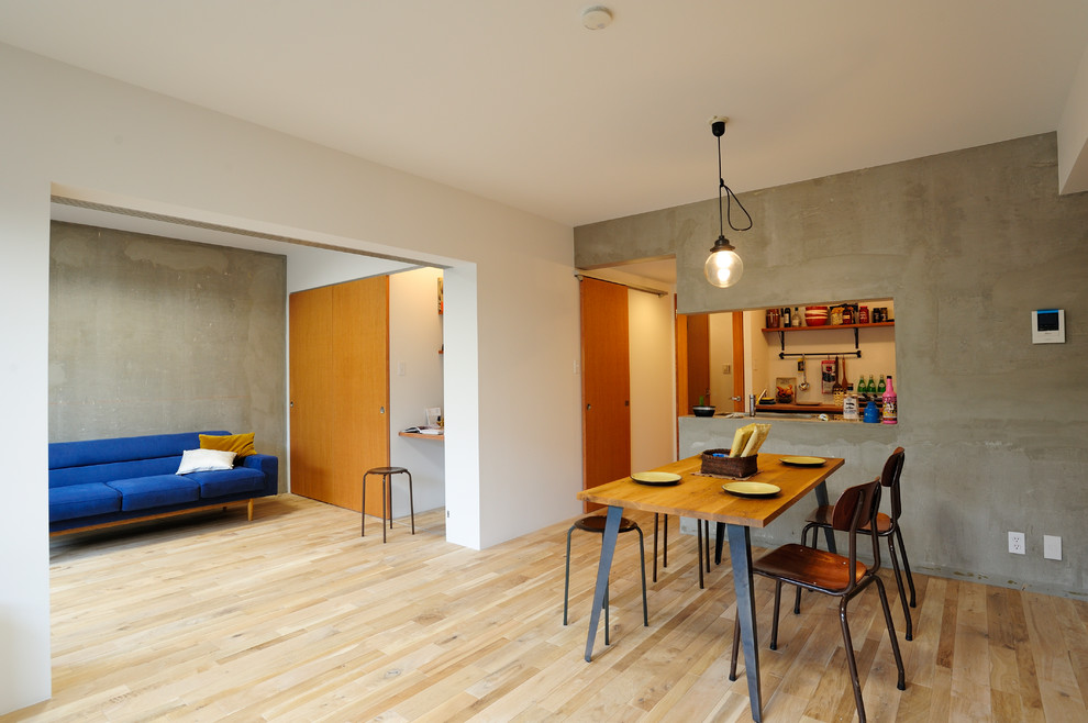 Esempio di una sala da pranzo aperta verso il soggiorno industriale con pareti multicolore, parquet chiaro e pavimento beige