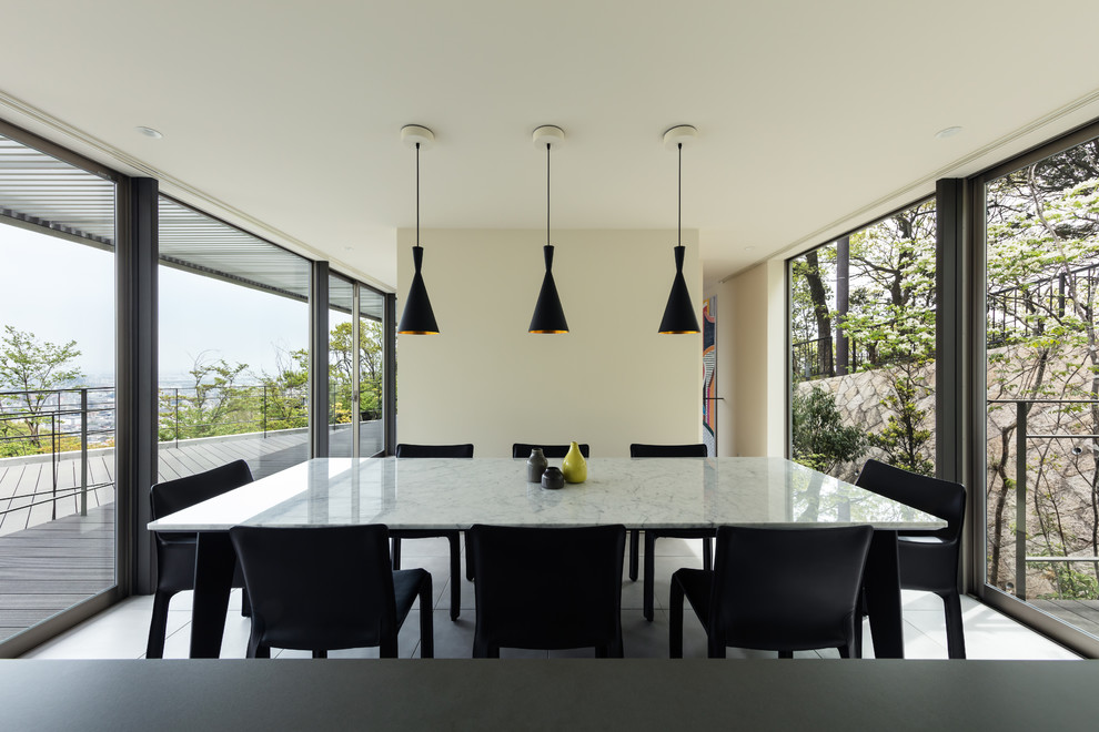 Пример оригинального дизайна: гостиная-столовая в стиле модернизм с белыми стенами, полом из керамогранита и серым полом