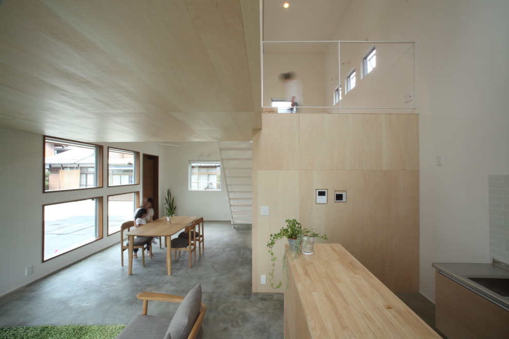 Стильный дизайн: маленькая гостиная-столовая в скандинавском стиле с белыми стенами, бетонным полом и серым полом для на участке и в саду - последний тренд