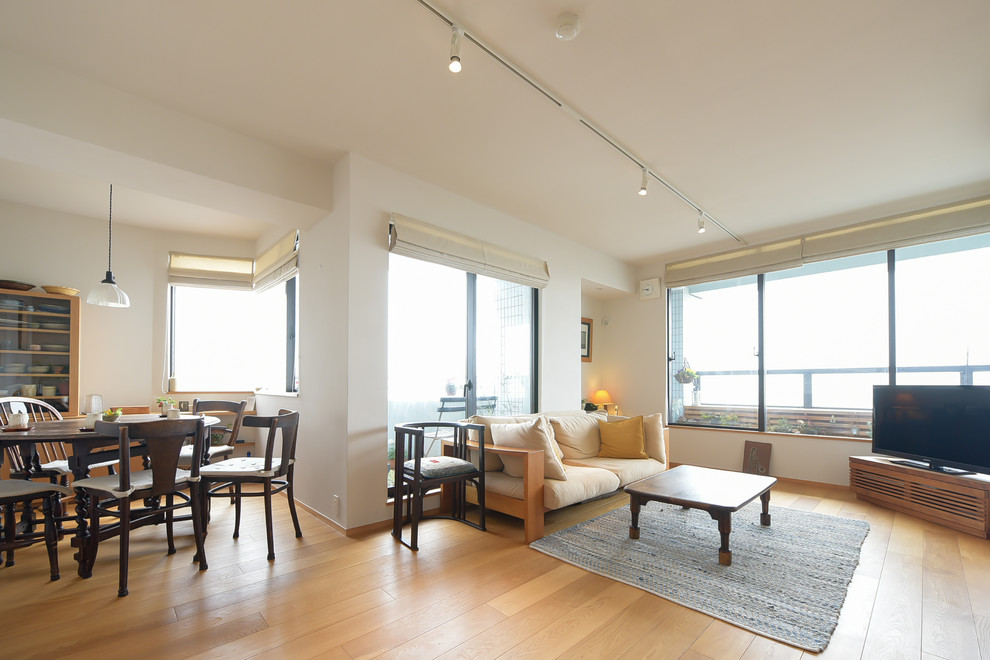 Стильный дизайн: гостиная-столовая в современном стиле с белыми стенами, светлым паркетным полом и коричневым полом - последний тренд