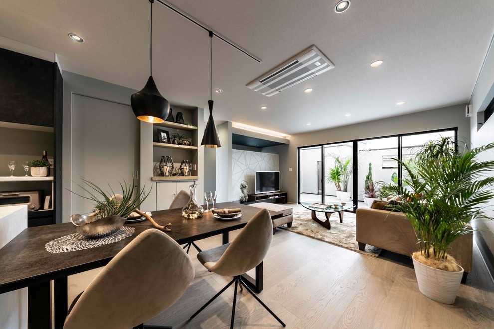 Esempio di una sala da pranzo aperta verso il soggiorno moderna di medie dimensioni con pareti grigie, pavimento in legno verniciato e pavimento beige