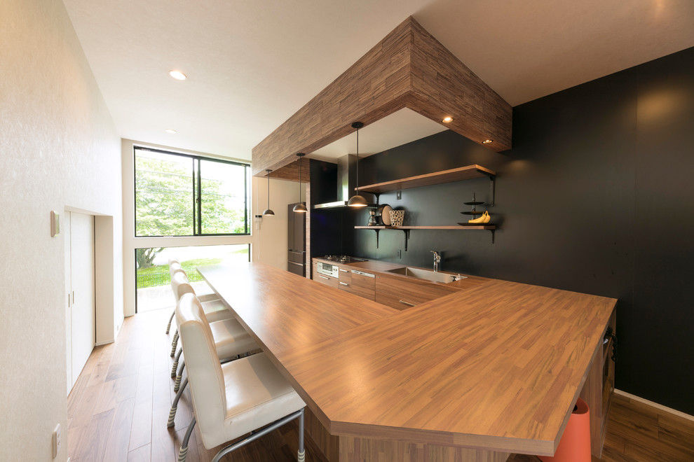 Источник вдохновения для домашнего уюта: столовая в скандинавском стиле с черными стенами, паркетным полом среднего тона и коричневым полом