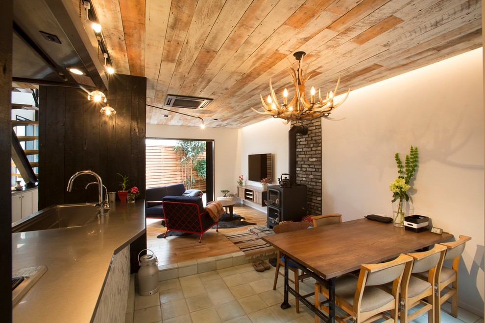 World-inspired dining room in Tokyo Suburbs with white walls, a wood burning stove and a brick fireplace surround.