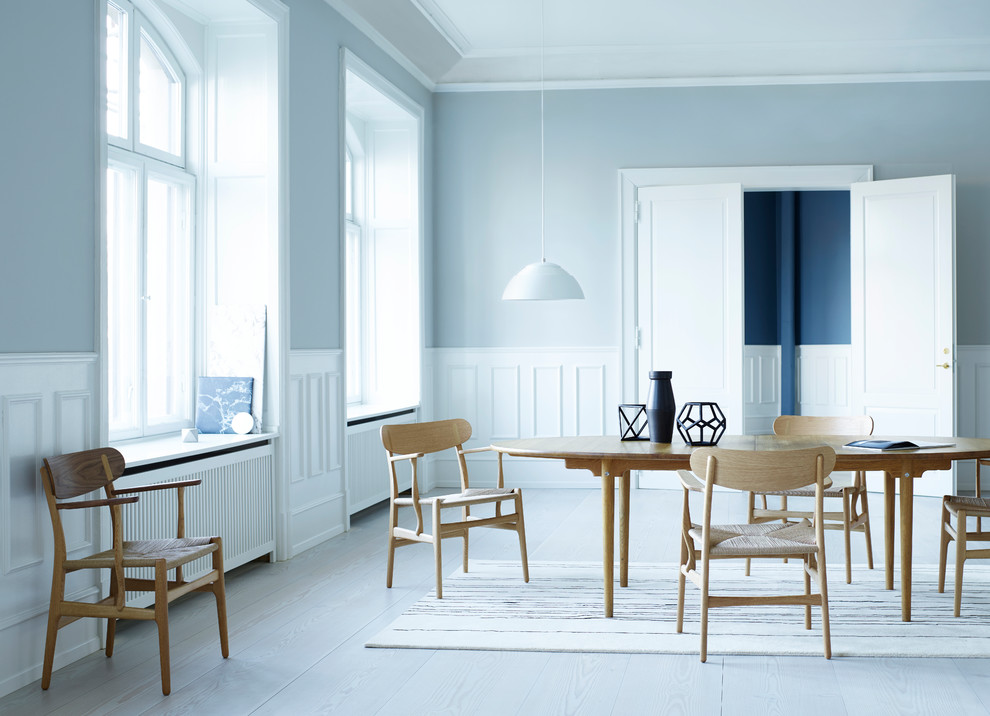 На фото: столовая в скандинавском стиле с синими стенами, деревянным полом и серым полом с
