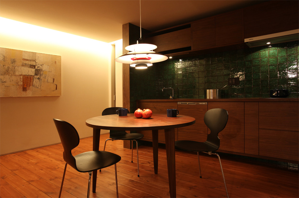 Modern inredning av ett litet kök med matplats, med vita väggar, mellanmörkt trägolv och brunt golv