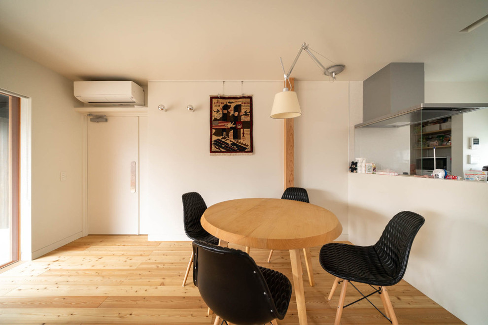 Idéer för en modern matplats, med vita väggar, ljust trägolv och beiget golv