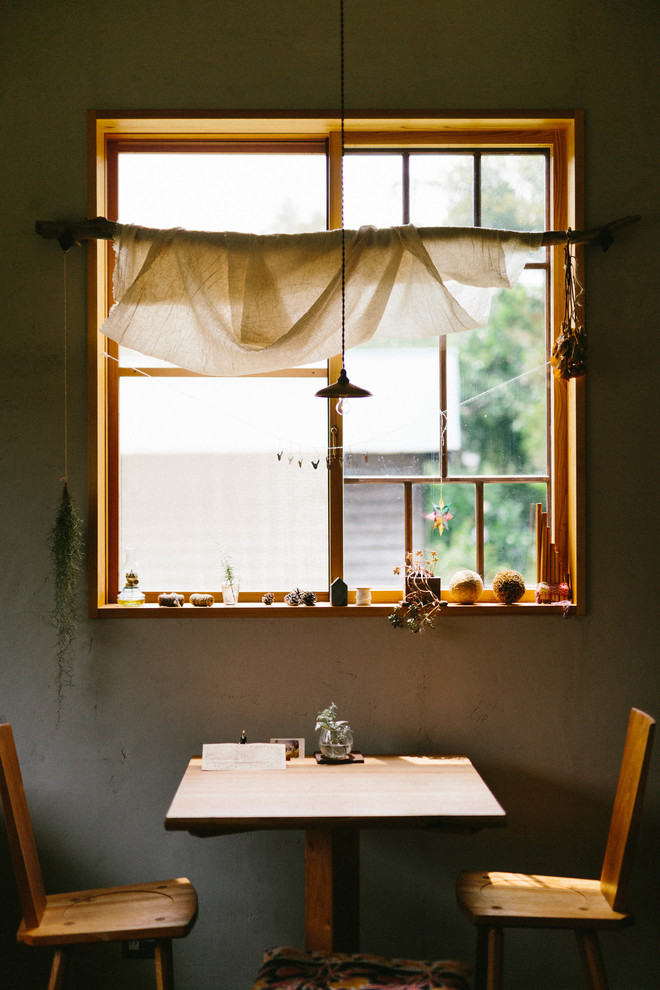 Exempel på en liten asiatisk matplats med öppen planlösning, med grå väggar, mörkt trägolv, en öppen vedspis och brunt golv