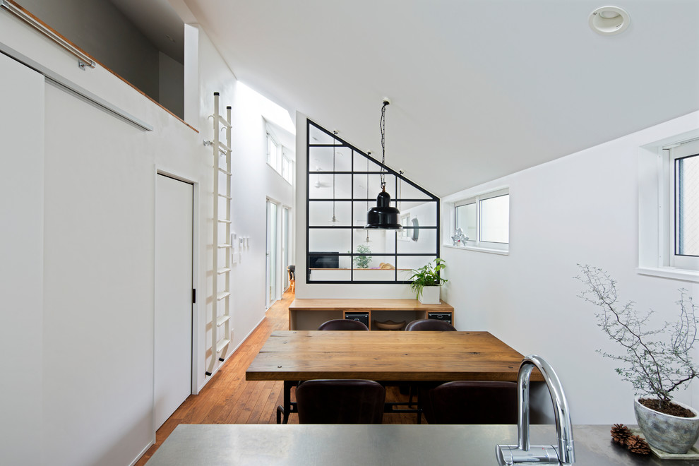 Moderne Wohnküche ohne Kamin mit weißer Wandfarbe, braunem Holzboden und braunem Boden in Tokio