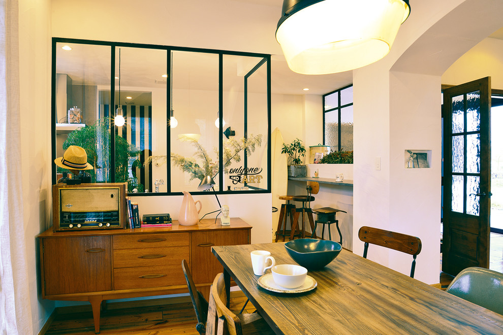 Immagine di una piccola sala da pranzo industriale con pareti bianche e pavimento in legno massello medio