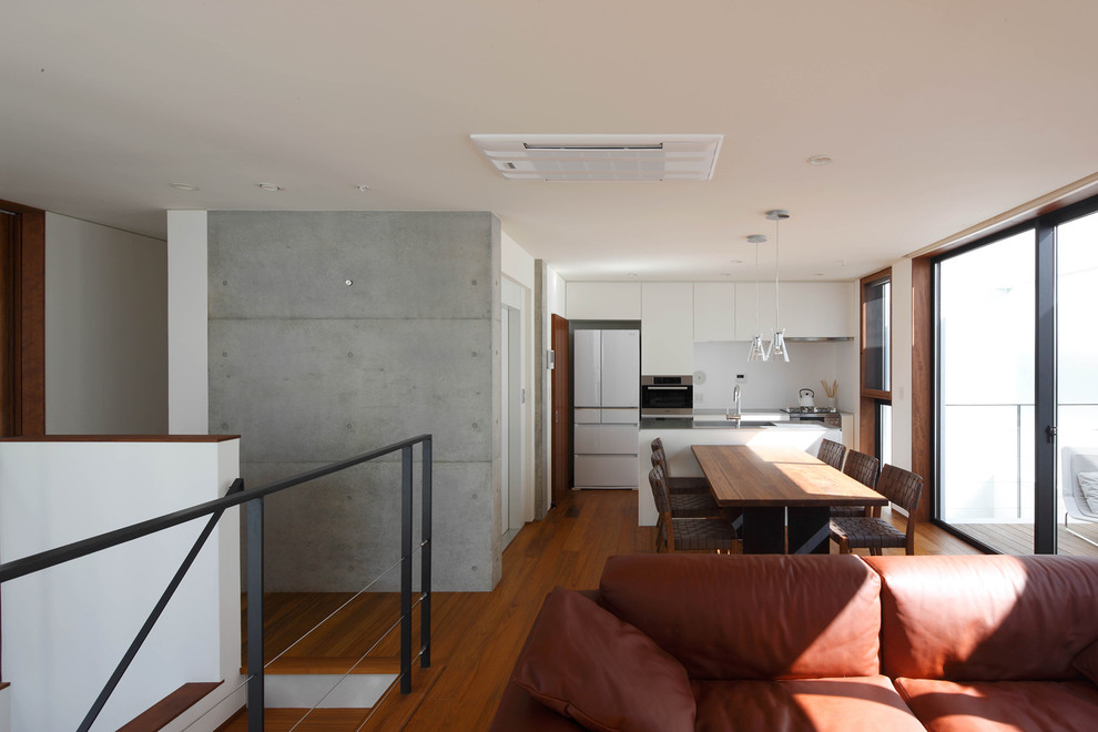 Example of a large minimalist dark wood floor and brown floor dining room design in Tokyo with multicolored walls