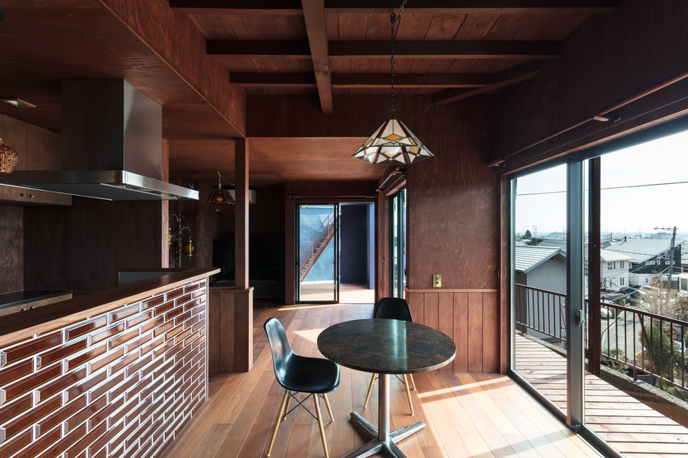 Aménagement d'une salle à manger ouverte sur le salon contemporaine avec un mur marron, un sol en bois brun et un sol marron.
