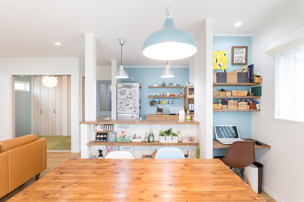 Immagine di una sala da pranzo aperta verso il soggiorno nordica con pareti multicolore, pavimento in legno massello medio e pavimento marrone