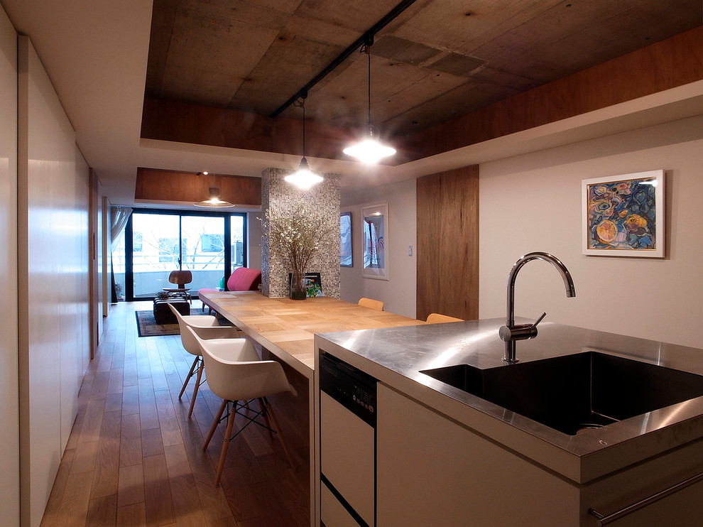 Пример оригинального дизайна: гостиная-столовая в стиле фьюжн с белыми стенами, паркетным полом среднего тона и коричневым полом