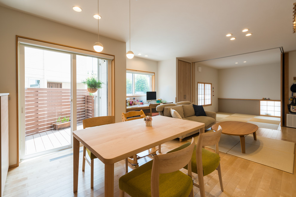 Immagine di una sala da pranzo aperta verso il soggiorno scandinava di medie dimensioni con pareti bianche, parquet chiaro e pavimento marrone