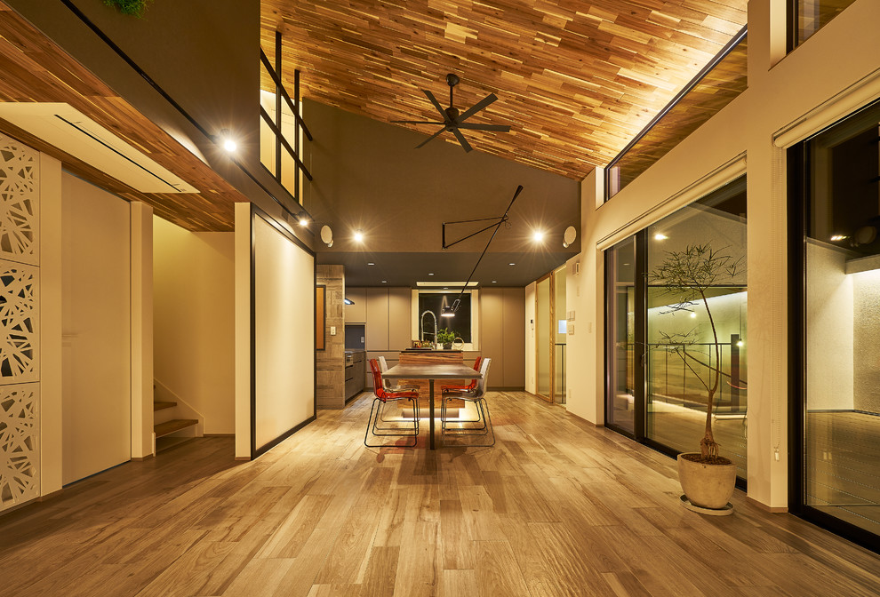 Ejemplo de comedor contemporáneo grande abierto con paredes blancas, suelo de madera en tonos medios y suelo marrón