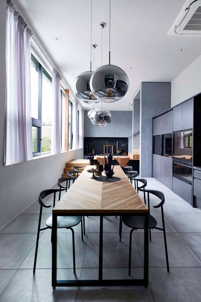 Diseño de comedor contemporáneo grande abierto con paredes blancas, suelo de cemento y suelo gris