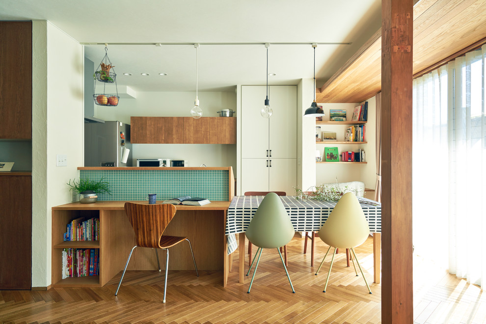 Idee per una sala da pranzo aperta verso la cucina nordica con pareti bianche e pavimento in legno massello medio