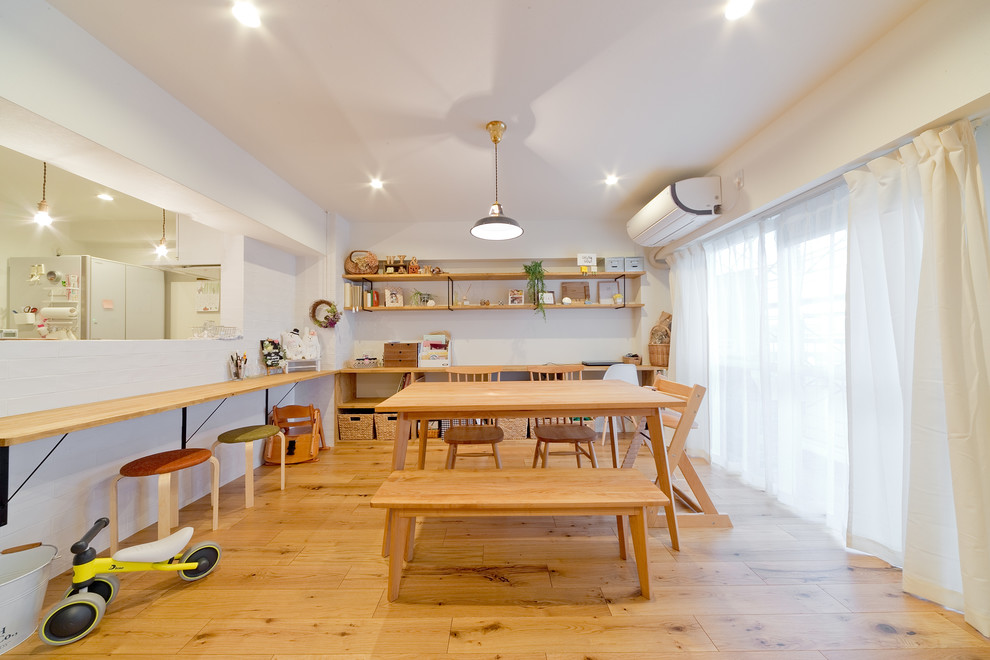 Foto di una sala da pranzo aperta verso il soggiorno etnica di medie dimensioni con pareti bianche, pavimento in legno massello medio e pavimento marrone