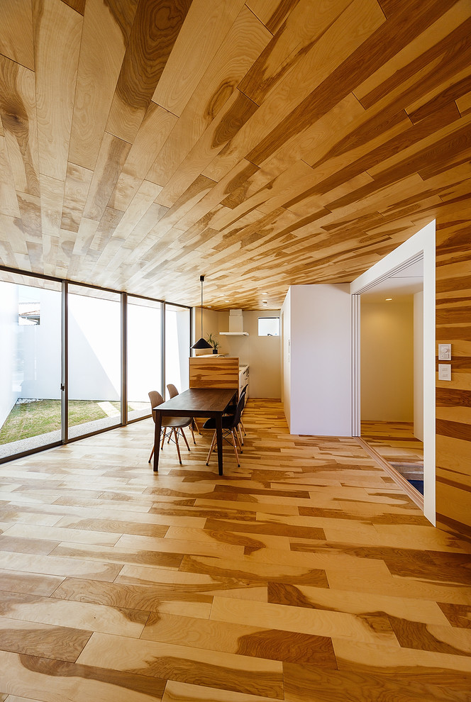 Esempio di una sala da pranzo aperta verso il soggiorno scandinava con pareti marroni, pavimento in legno verniciato e pavimento marrone