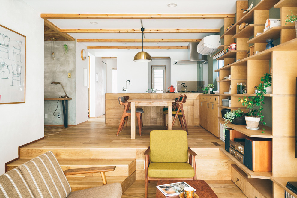 Idee per una sala da pranzo aperta verso il soggiorno industriale con pareti bianche, pavimento in legno massello medio e pavimento marrone