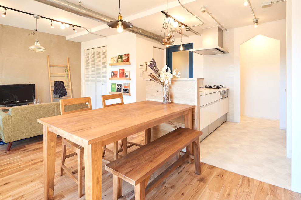 Cette photo montre une salle à manger ouverte sur le salon scandinave avec un mur multicolore, un sol en bois brun et un sol marron.