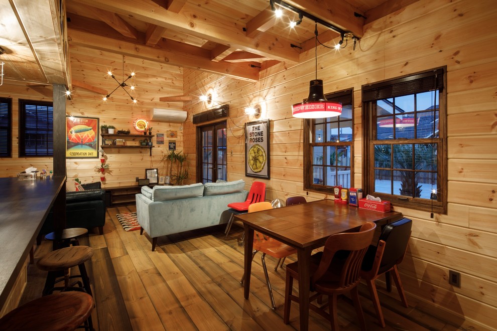 Cette photo montre une salle à manger ouverte sur le salon montagne avec un mur marron, un sol en bois brun et un sol marron.