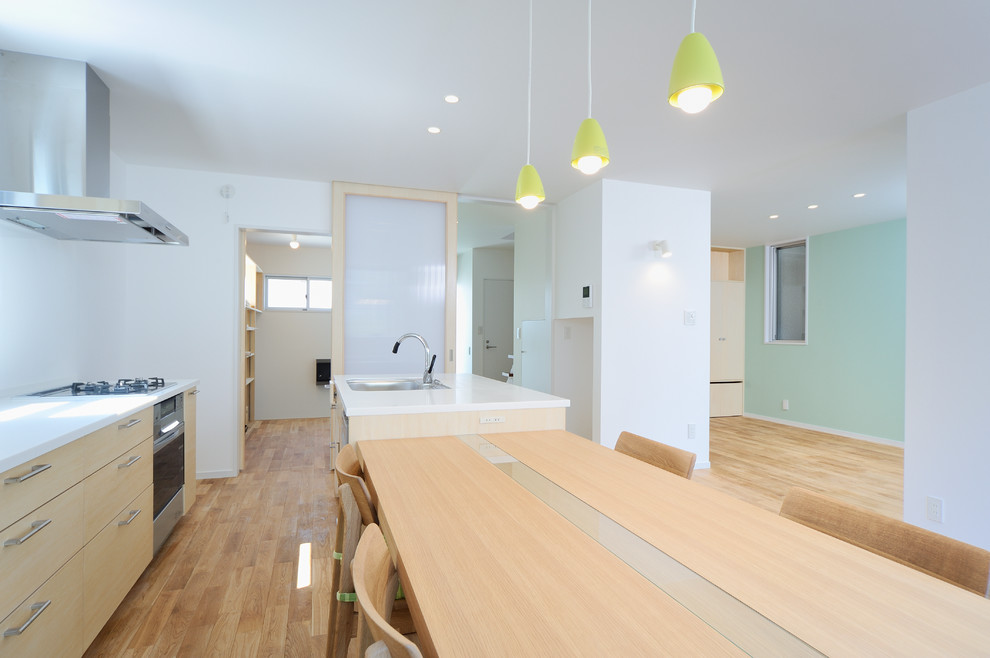 Immagine di una sala da pranzo aperta verso il soggiorno minimalista di medie dimensioni con pareti bianche, pavimento in legno massello medio e pavimento beige